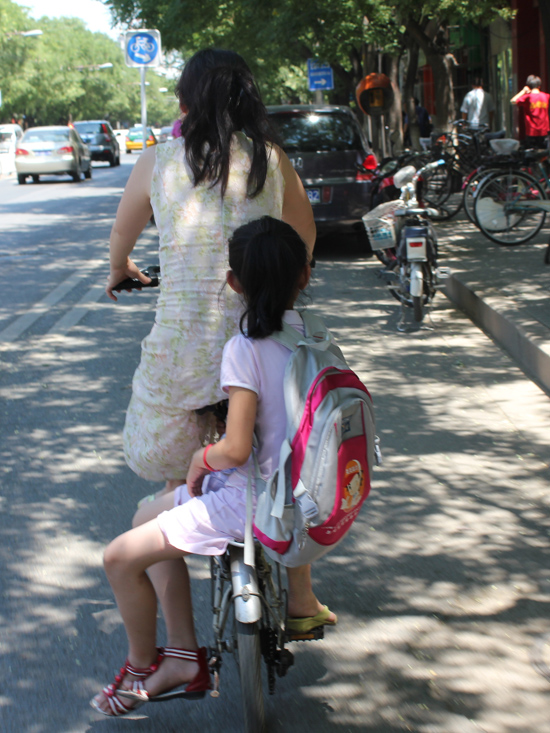 A child does a balancing act on a Beijing city stroll. Photo: Kim Bowden/PMC