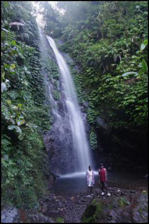 Local Kolombangara islanders Mofat and Jenny at one of the many waterfalls deep inside the crater. Image: Andrew Cox/Scoop