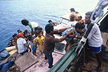 Rainbow Warrior crew helping Rongelap islanders board the ship for one of four voyages relocating them to Mejato islet in May 1985. Image: David Robie/Eyes of Fire