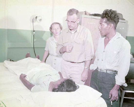 Jabwe, the Rongelap health practitioner, assists Nurse Lt. M. Smith and Dr. Lt. J. S. Thompson, during a medical examination on Kwajalein, 11 March 1954. From DTRIAC SR-12-001.
