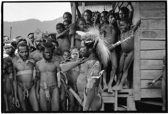 THE ORIGINAL PHOTO BEFORE BEING CENSORED BY FACEBOOK: West Papua: An OPM guerrilla with cassowary headdress during an independence flag-raising ceremony in the Highlands, 1995. © Ben Bohane