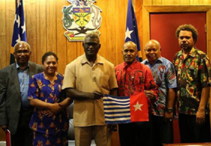 Full support … West Papuan Independence leader Benny Wenda (in red shirt) holds the banned West Papuan Morning Star flag with key supporter Solomon Islands Prime Minister Manasseh Sogavare during his visit last year. Image: bennywenda.org