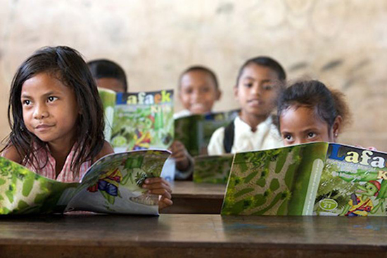 School children at Leo Hitu Primary School read their copies of CARE educational magazine, Lafaek in Bobonaro, Timor-Leste. Image: Jane Dempster/CARE