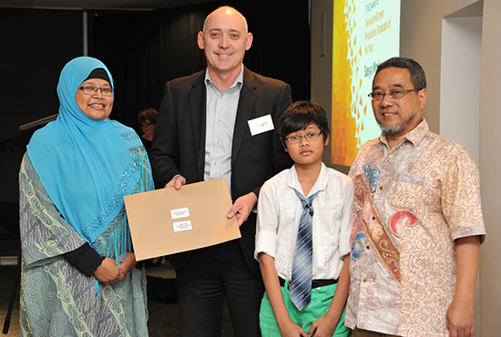 Brent McAulty, TVNZ's head of legal affairs, presenting Saysa Wreksono’s Graduating Television/Screen Production Student of the Year award to her parents, Hanny and Sony Ambudi, and her young brother Dio. Image: Doug Cole/AUT