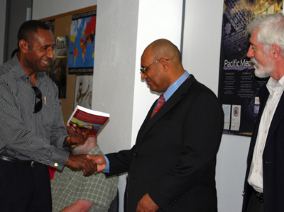 Henry Yamo, one of the book authors, presents a signed copy to PNG High Commissioner William Dihm. Photo: Del Abcede