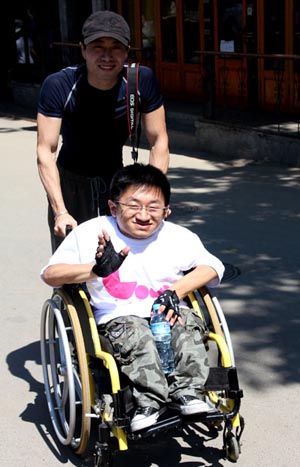 A wheelchair participant receives a helping hand at the charity walkathon. Photo: Kim Bowden/China Daily