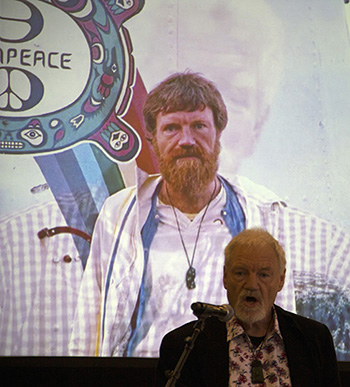 David Robie at the Eyes of Fire book launch. Image: Del Abcede; background image from 1985, John Miller.