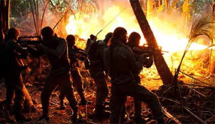 A flame thrower clears the jungle before the cave in the final assault at Gossanna. Image: Rebellion