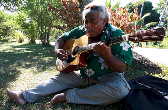  Musician and activist Vincent Eurisouké performs Kanaky Mon Beau Pays at the mourning ceremony for a local pastor. Image: Jim Marbrook/PMC