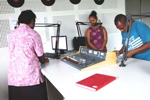 Chrisnrita Aumanu and Charles Kadamana reading the radio news bulletin in the Radio Pasifik studio