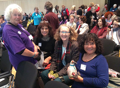 Some of the WILPF Aotearoa delegates: Ruth Coombes (standing), Celine Kearney and Del Abcede with Rangimarie (the kiwi mascot). 